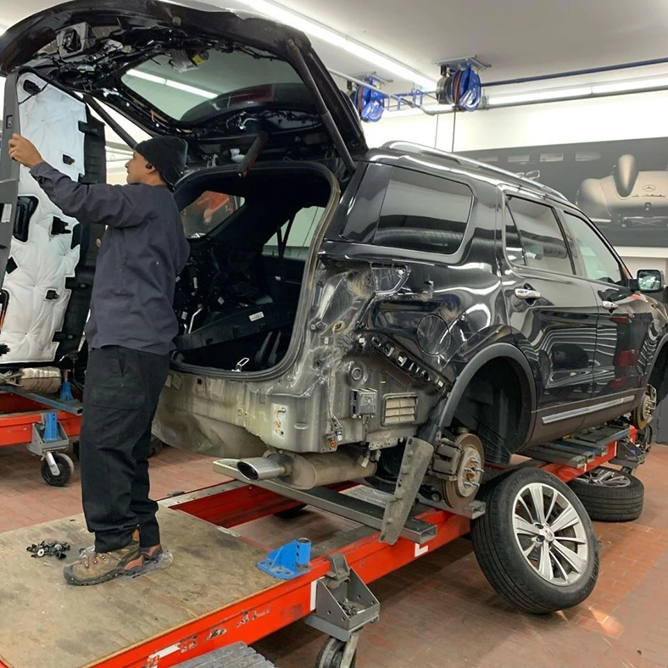 Vehicle undergoing structural collision repairs in a workshop