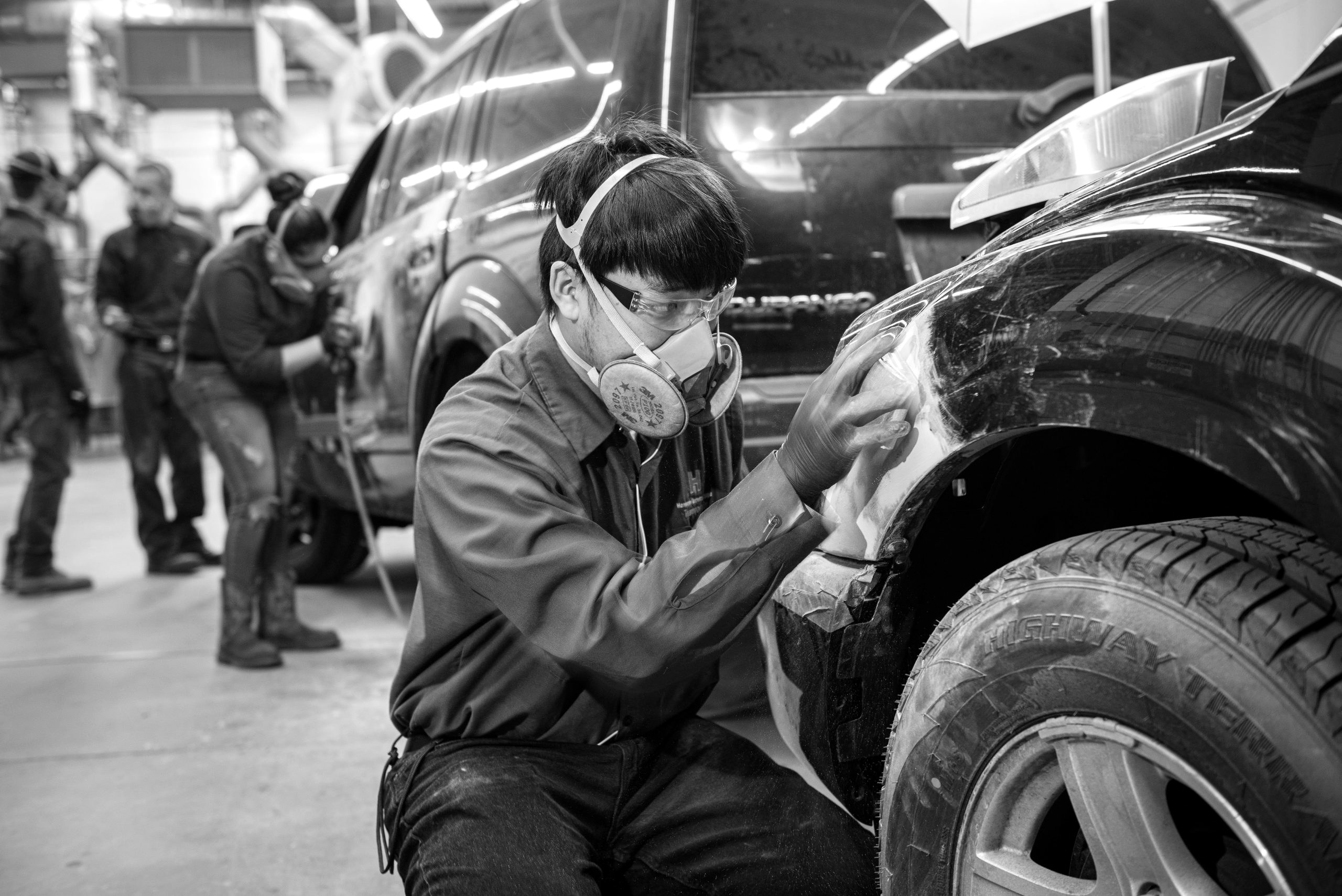 Technician repairing collision damage to an exterior panel